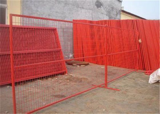 Czerwone tymczasowe ogrodzenie z siatki z plastikowymi i żelaznymi stopami na plac budowy